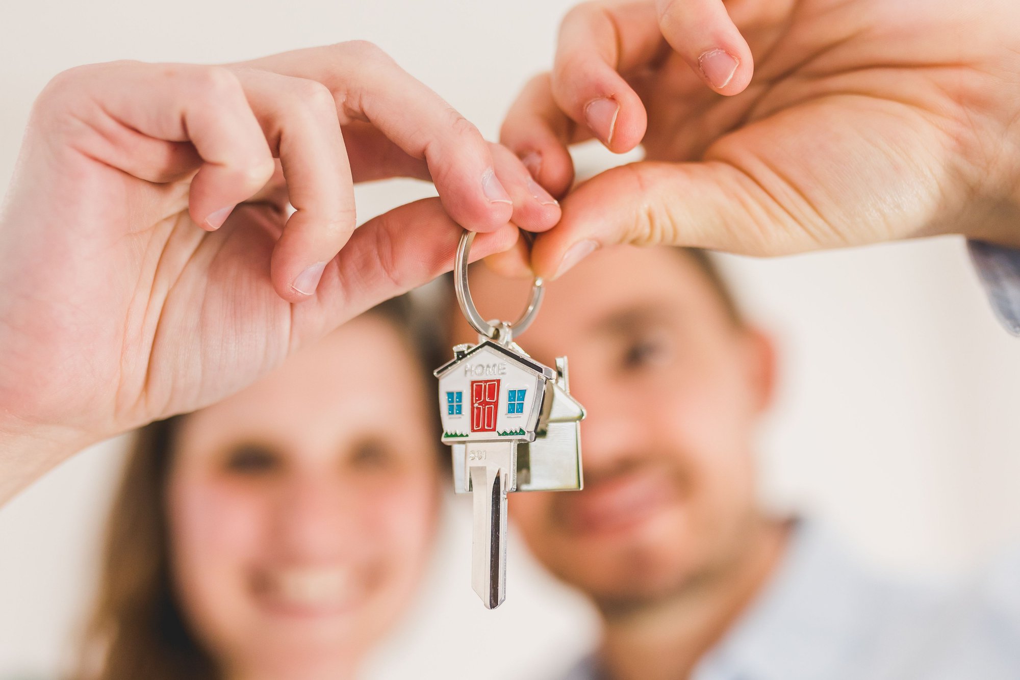 A couple with their house key, purchased from a first-time homebuyer credit program.